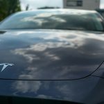 A tesla car reflecting the cloudy sky.